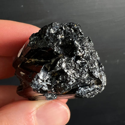 Schwarzer Turmalin roh, tiefschwarz mit metallisch-silbrigem Glanz, prismatische Kristallstruktur, raue Oberfläche | Happy Minerals