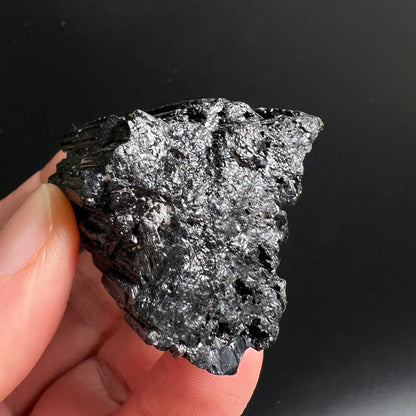 Schwarzer Turmalin roh, tiefschwarz mit metallisch-silbrigem Glanz, prismatische Stängelstruktur, raue Oberfläche | Happy Minerals