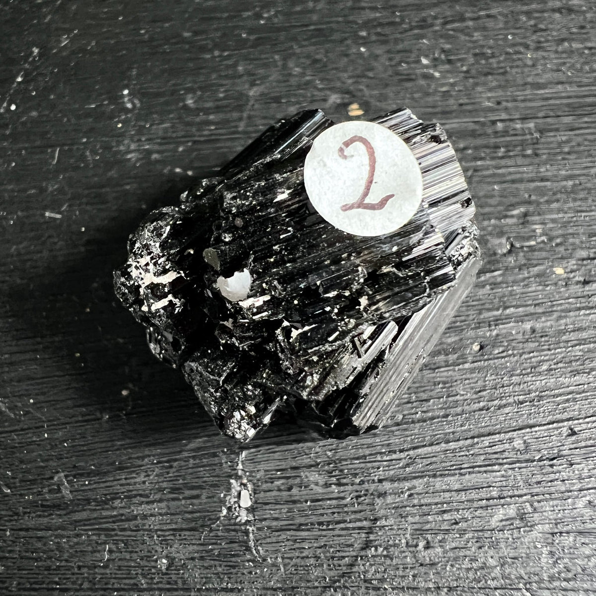 Schwarzer Turmalin roh, tiefschwarz mit vertikalen Riefen, metallischem Glanz und weißen Mineraleinschlüssen | Happy Minerals