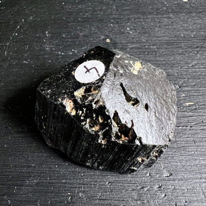 Schwarzer Turmalin roh, tiefschwarz mit vertikalen Striemen, goldbeige Einschlüsse, matter u. glänzender Bereich | Happy Minerals