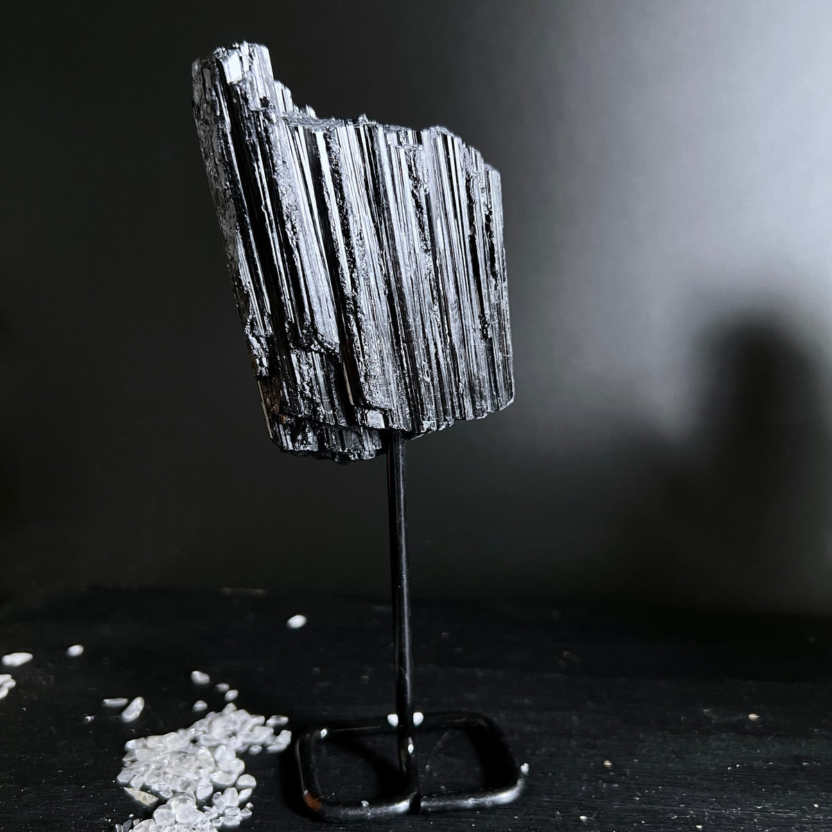 Schwarzer Turmalin Rohstein mit parallelen Faserstreifen und Metallglanz auf Metallständer | Happy Minerals