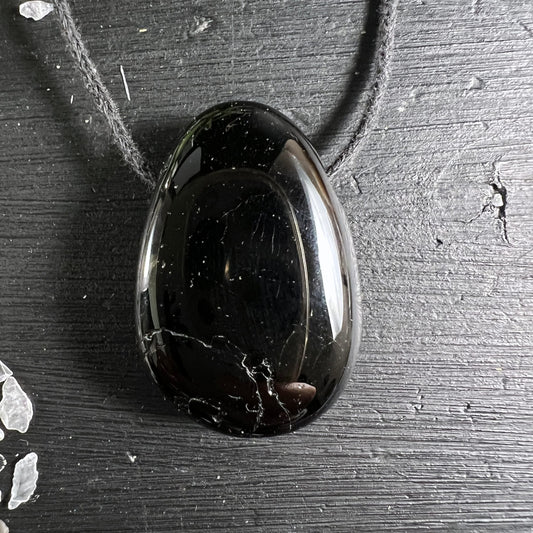 Schwarzer Turmalin Tropfen | glänzend | auf dunklem Holz | grauer Schnur | Madagaskar | Happy Minerals
