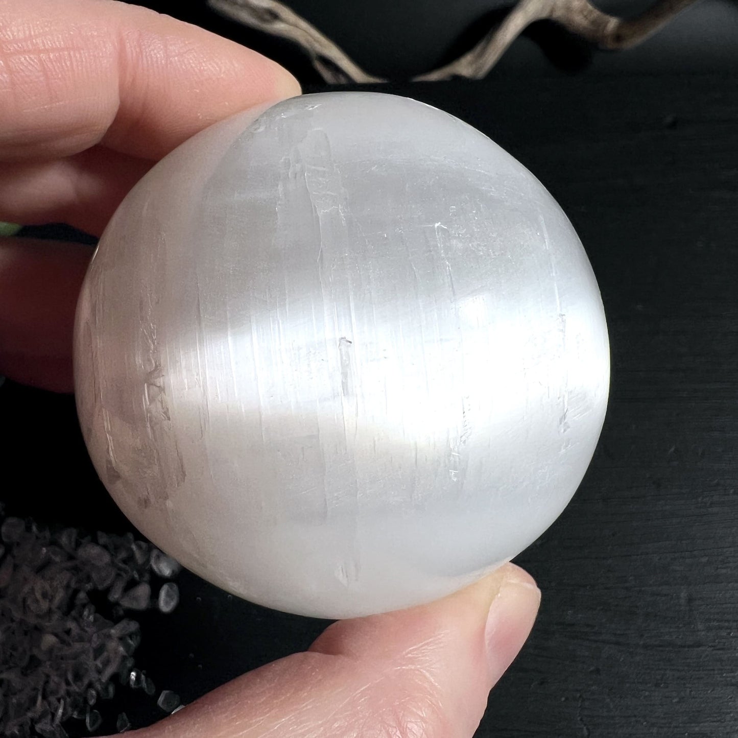 Natürliche Kristallstrukturen im Inneren der Selenitkugel sichtbar durch seidigen Glanz