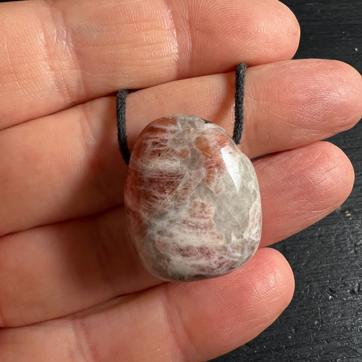 Sonnenstein | Anhänger | in | Hand | schwarzes | Band | natürliche | Maserung | Happy Minerals