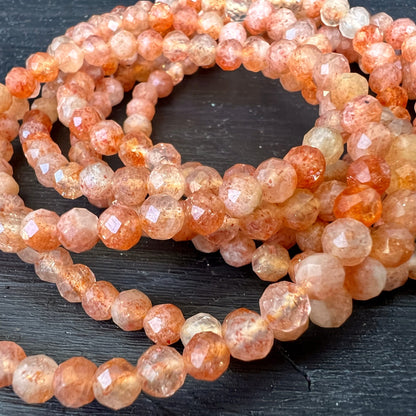 Sonnenstein Tansania | 4mm Perlen facettiert | Nahaufnahme | funkelnde Facetten | leuchtendes Orange | Happy Minerals