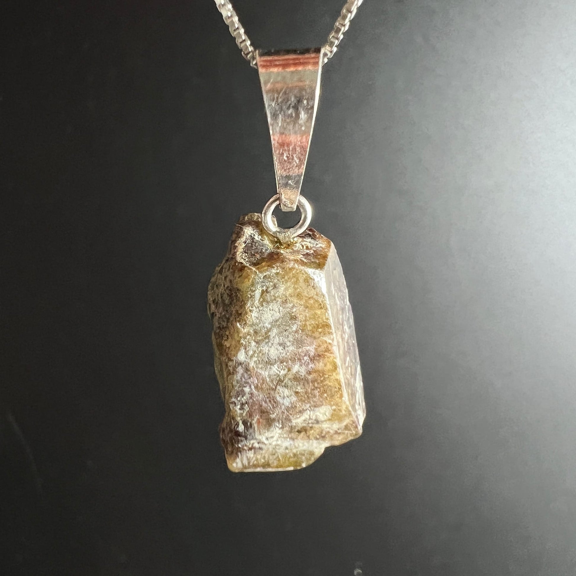 Sphen Rohkristall Anhänger, honiggelb-braun mit violett-rosanen Schlieren, glasiger Glanz, quaderförmig roh, 925 Silberöse | Happy Minerals
