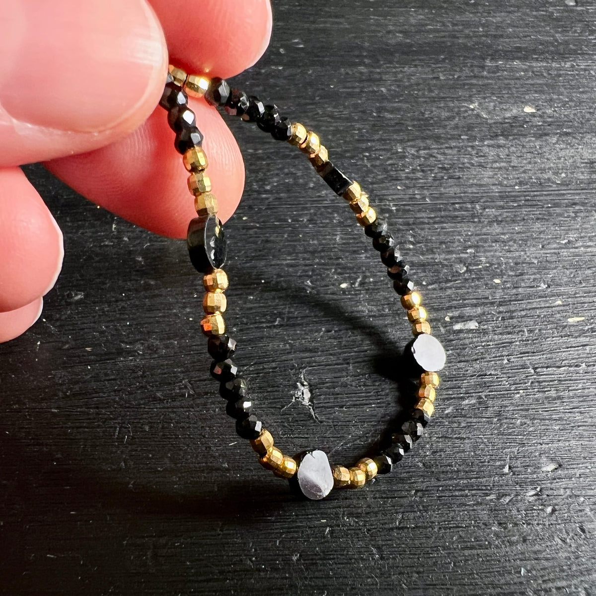 Spinell | Armband | Handdetail | schwarz-gold | facettierte Kugeln | Happy Minerals