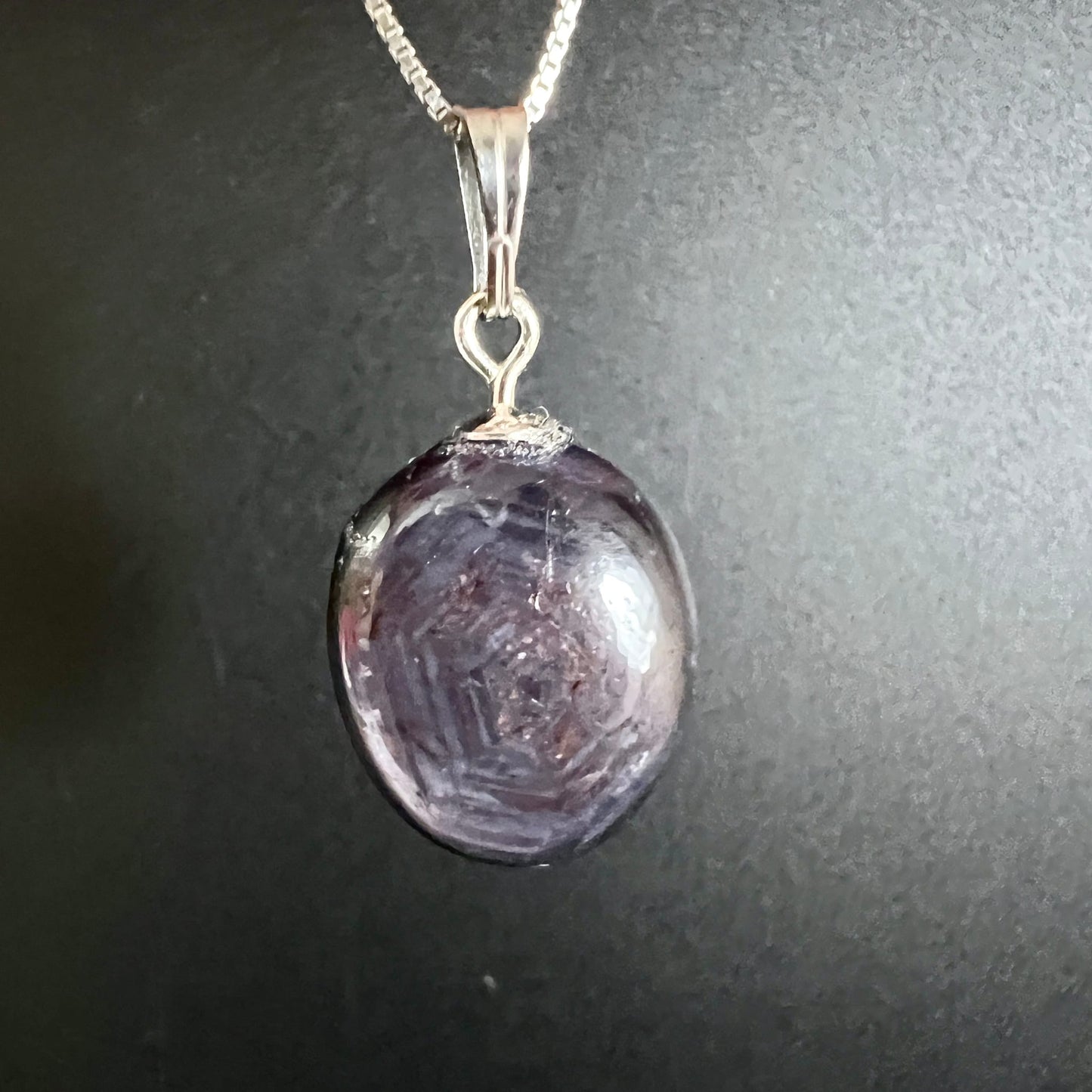 Sternrubin Cabochon oval, violett-lila mit konzentrischen Wachstumszonen und sichtbarem Asterismus-Stern, Silberöse | Happy Minerals