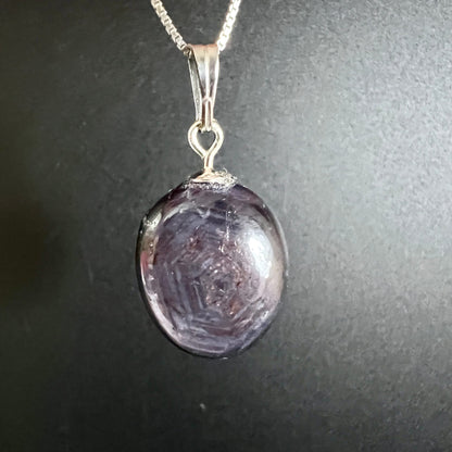 Sternrubin Cabochon oval, violett-lila mit konzentrischen Wachstumszonen und sichtbarem Asterismus-Stern, Silberöse | Happy Minerals