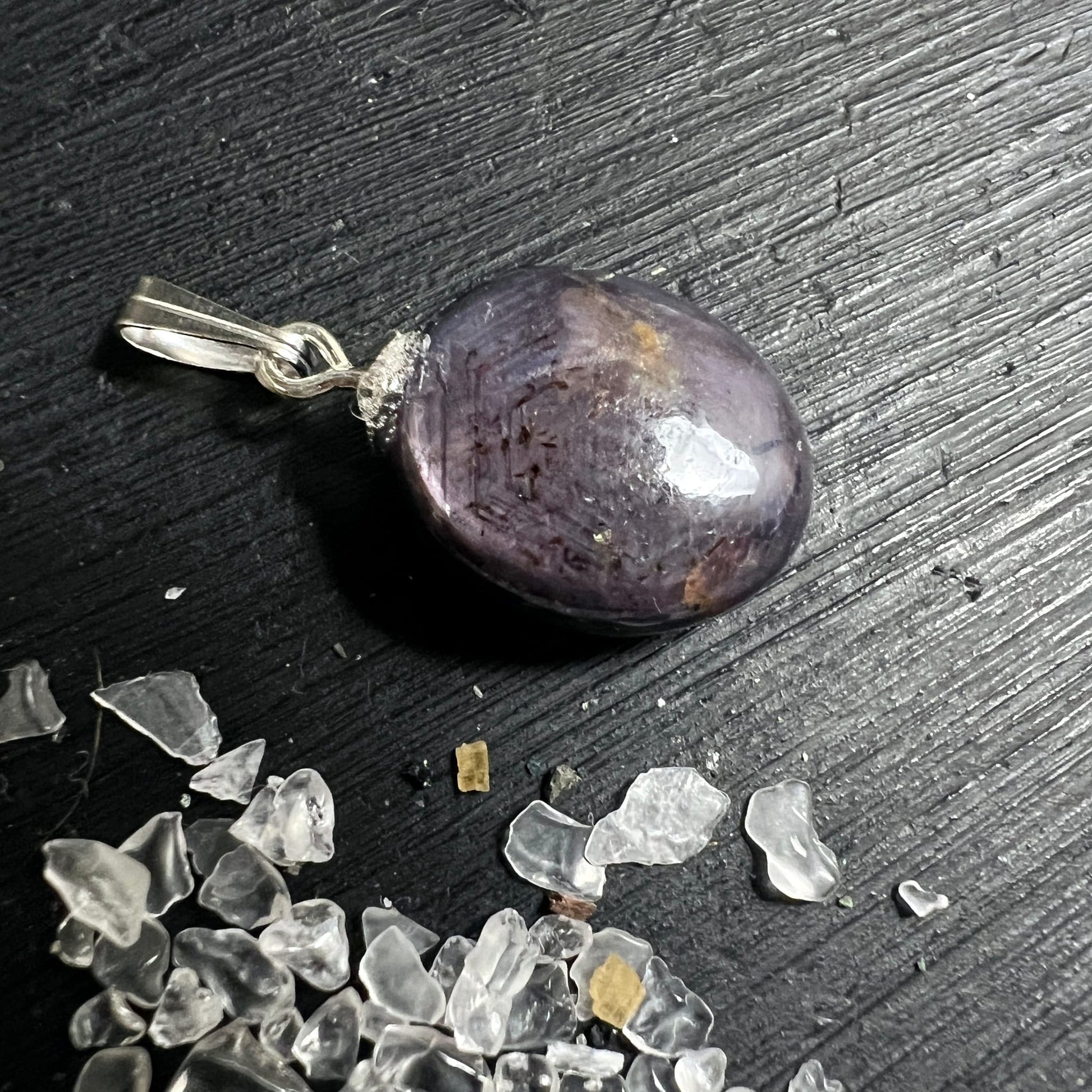 Sternrubin Cabochon oval poliert, violett-lila mit goldbraunen Flecken, dunklen Nadeleinschlüssen, silberne 925 Öse | Happy Minerals