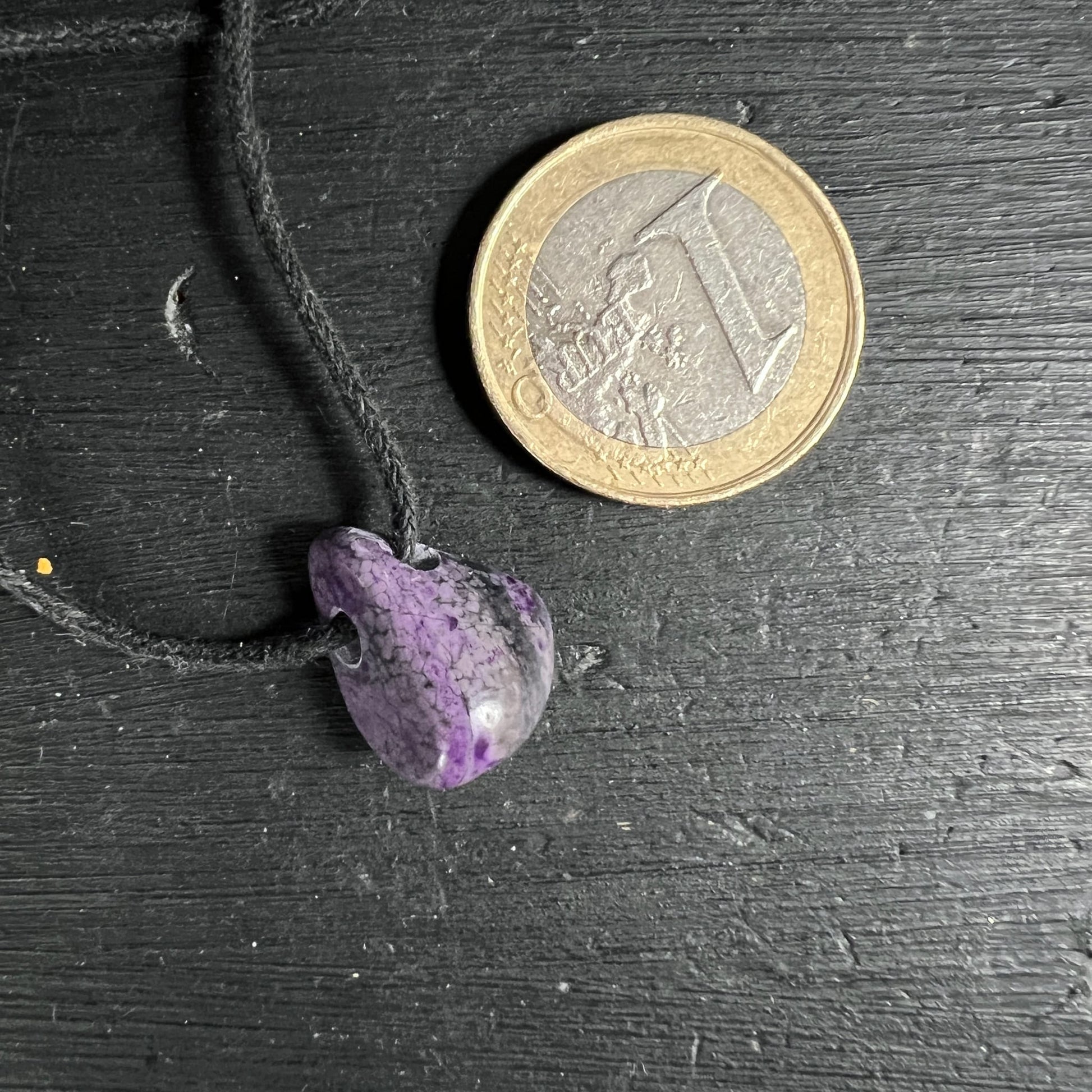 Sugilith Anhaenger violett-grau marmoriert, tropfenfoermig poliert an schwarzer Kordel, Groessenvergleich Muenze | Happy Minerals
