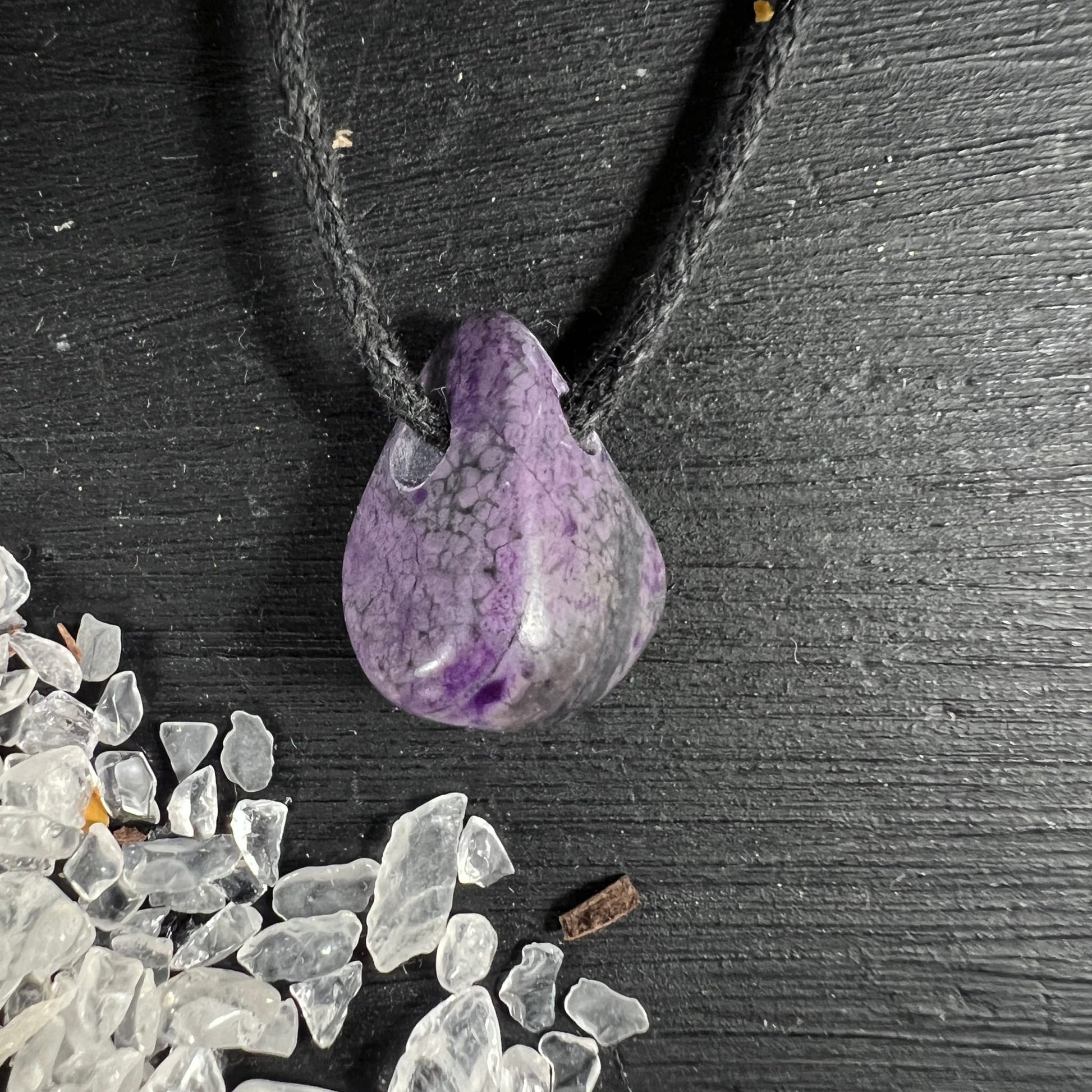 Sugilith Anhaenger tropfenfoermig, violett-grau marmoriert mit dunklen Adern, an schwarzer Kordel | Happy Minerals