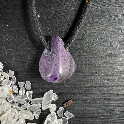 Sugilith Anhaenger tropfenfoermig, violett-grau marmoriert mit dunklen Adern, an schwarzer Kordel | Happy Minerals