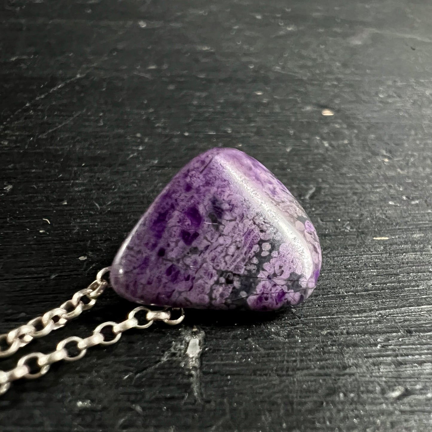 Sugilith Anhaenger dreieckig-oval poliert, violett-lila mit dunklen und weissen Marmorierungen, Silberkette | Happy Minerals