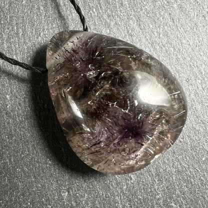 Super Seven Tropfen-Anhänger, rauchig-transparent mit violett-schwarzen Faserbüscheln und silbrigen Rutil-Nadeln | Happy Minerals