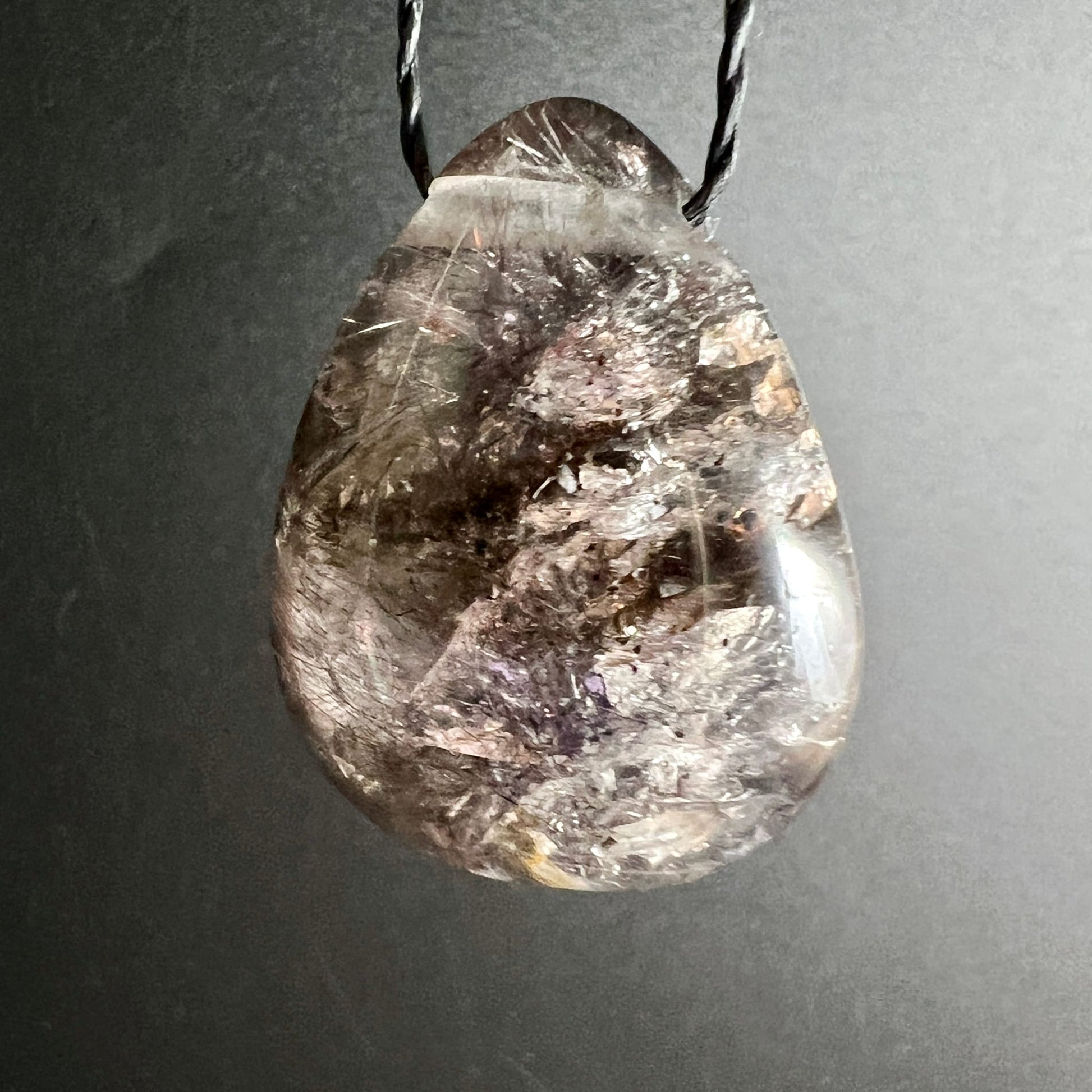 Super Seven Tropfen-Anhänger, rauchig-transparent mit violetten Amethyst-Zonen, schwarzen Einschlüssen und silbrigen Nadeln | Happy Minerals