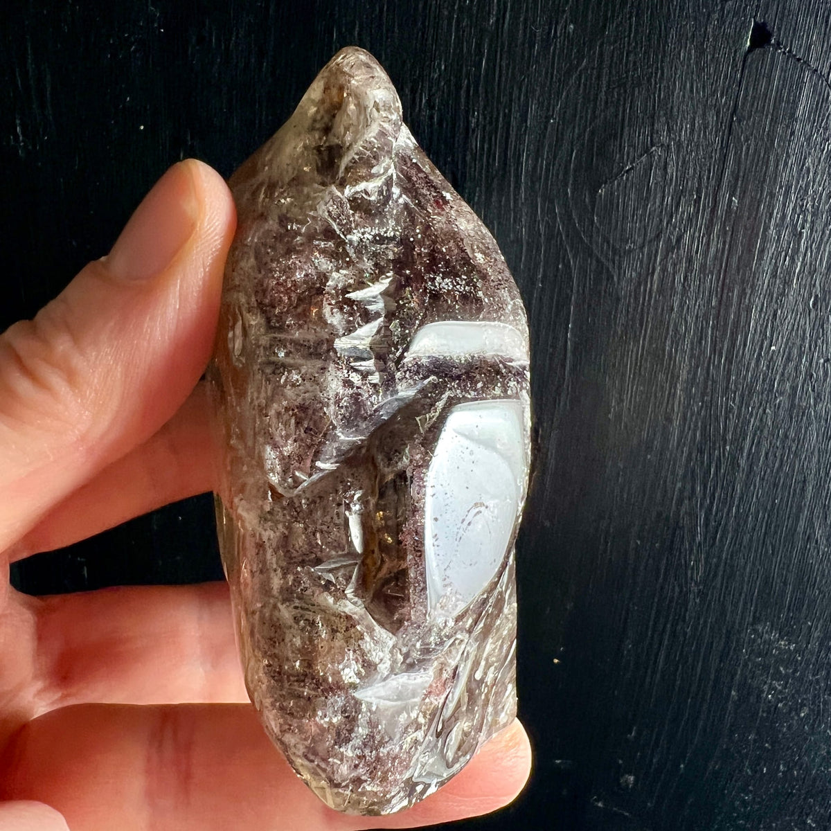 Super Seven Kristall | Seitenansicht in Hand | milchige Einschlüsse | erdige Nuancen | Happy Minerals