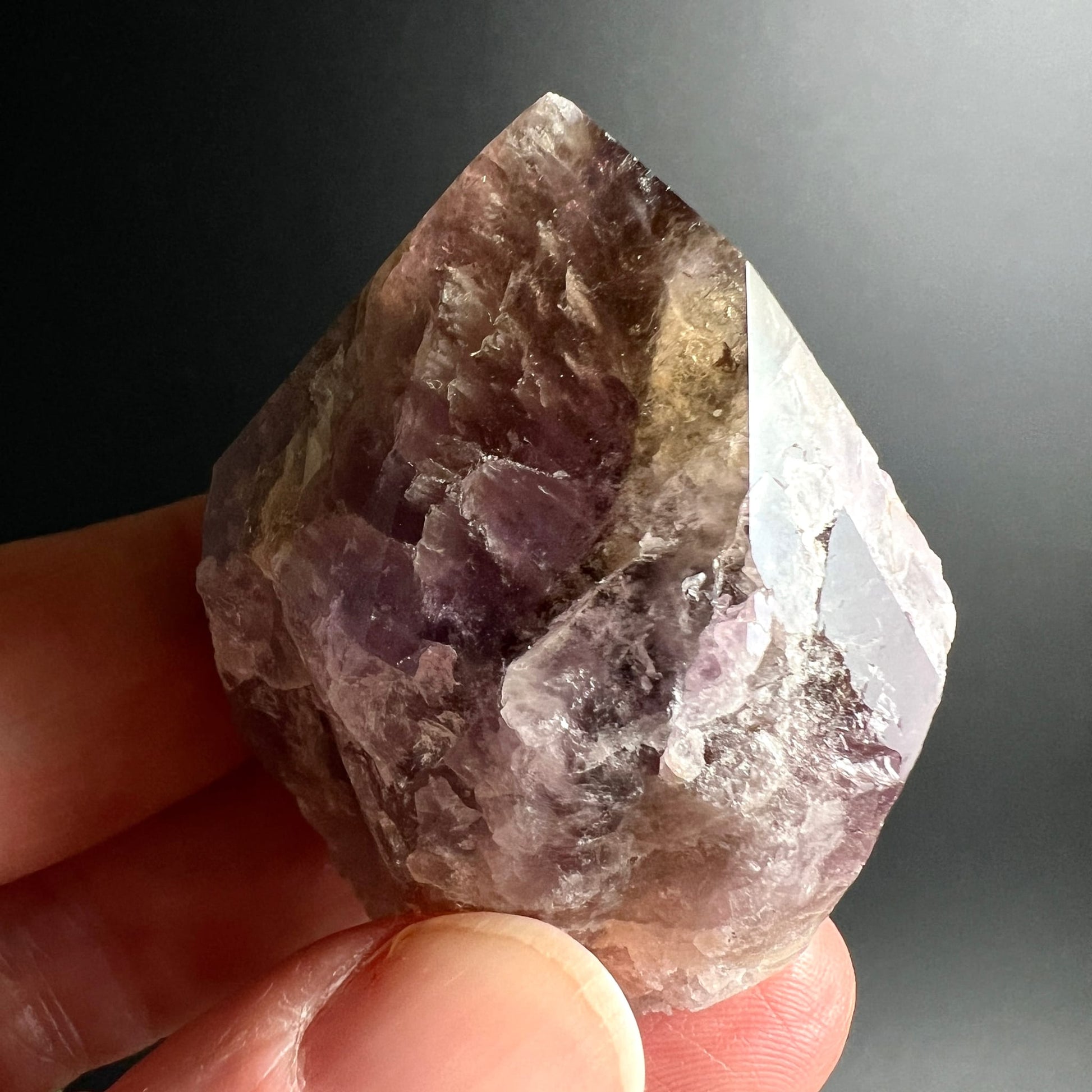 Super Seven Melody Stone | Variante A | Nahaufnahme Hand | violett lila | tiefe Einschluesse | Happy Minerals