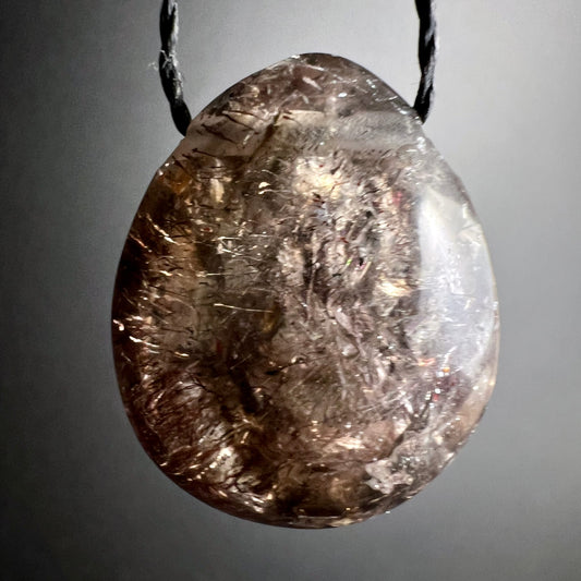 Super Seven Anhänger | frontal | grauer Hintergrund | violette Schlieren | dunkle Einschlüsse | Unikat | Happy Minerals