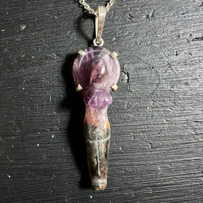 Melody Stone Göttin liegend | Kette sichtbar | dunkler Untergrund | erdige Farbtöne | Happy Minerals