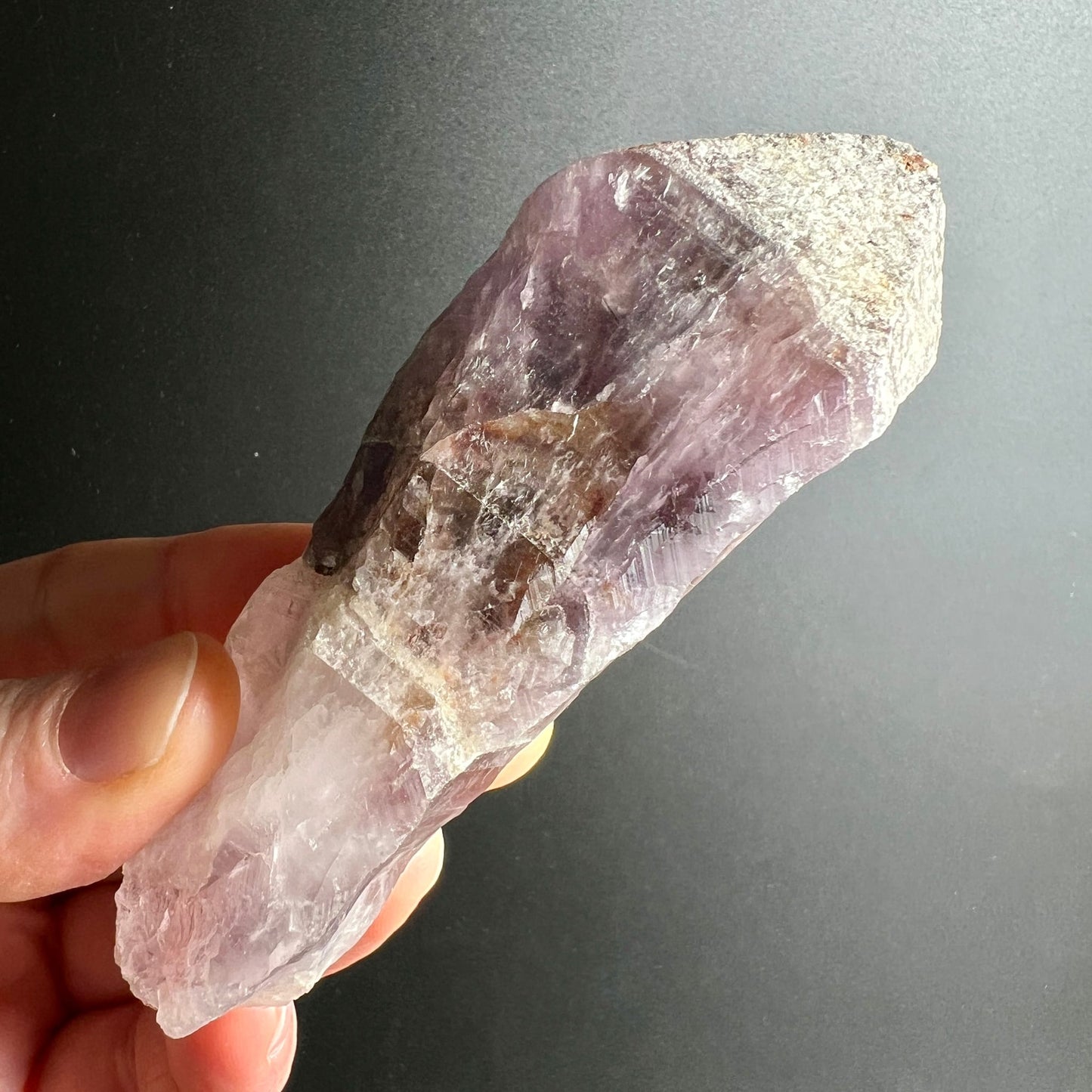 Super Seven Melody Stone | in der Hand | tiefe Amethyst-Zonen | natürliche Kristallstruktur | Brasilien | Happy Minerals
