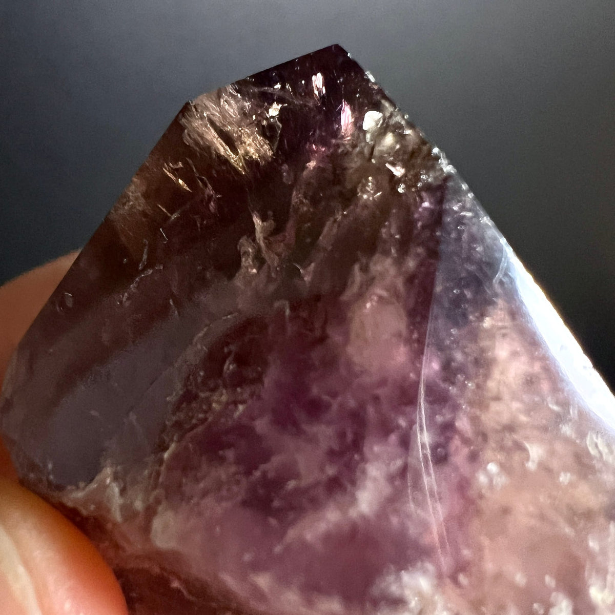Super Seven Kristallspitze mit dunkelvioletten und rauchbraunen Zonen, feinen Faser-Einschluessen und facettierter Spitze | Happy Minerals