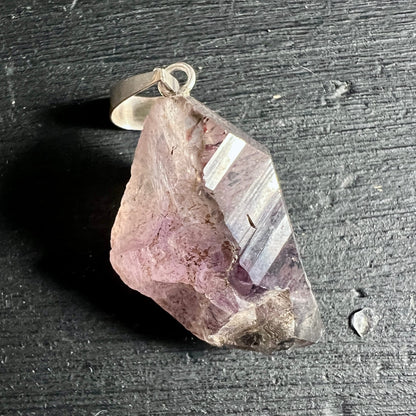 Roh belassener Kristallanhänger in rosa-violetten Tönen mit klarer Spitze und Silberöse | Happy Minerals