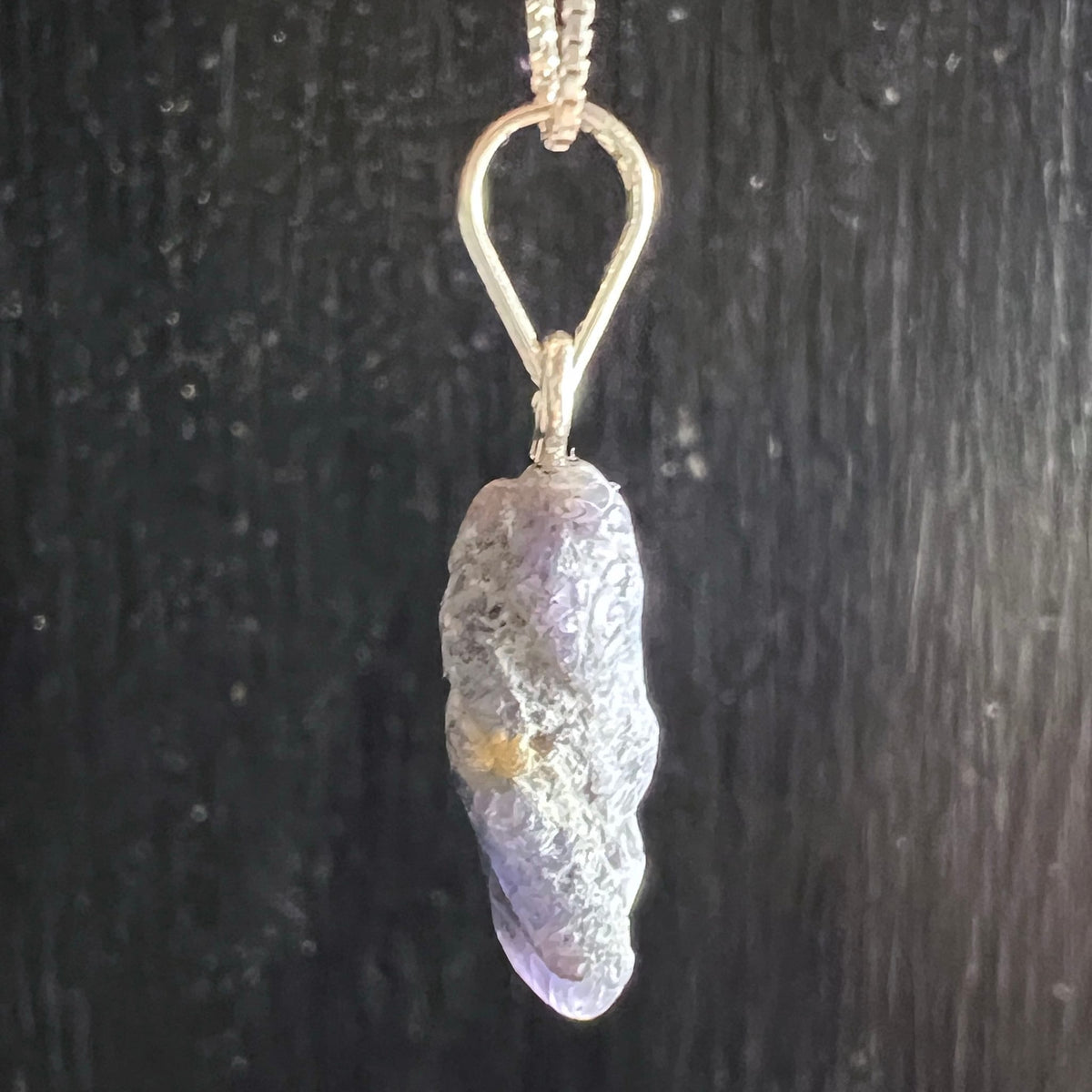 Roher Tansanit Anhaenger, laenglich, silbrig-lila schimmernde Oberflaeche mit gelbem Einschluss, Silberoese | Happy Minerals