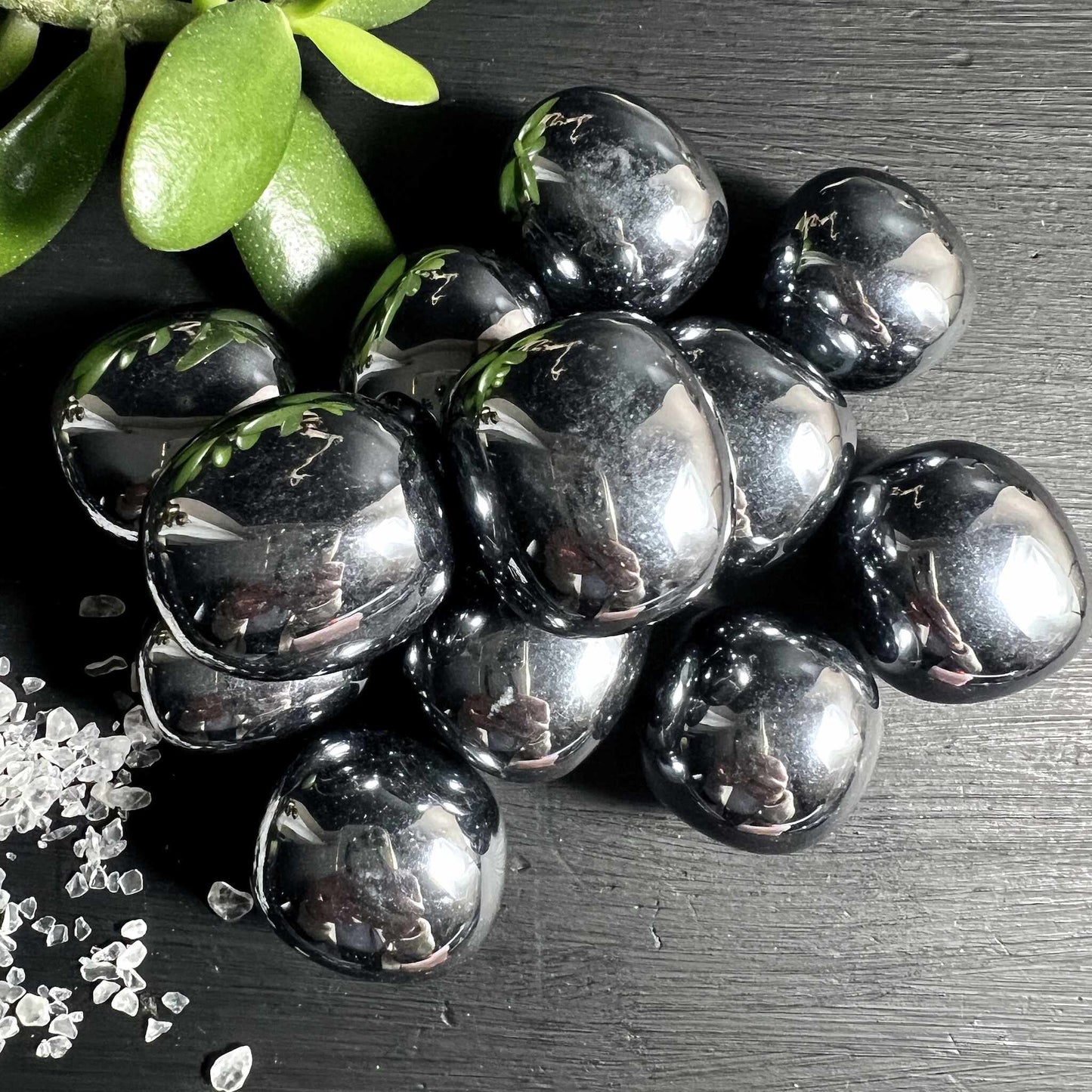  Terahertz Trommelsteine glaenzen wie fluessiges Silber auf dunklem Holz | Happy Minerals