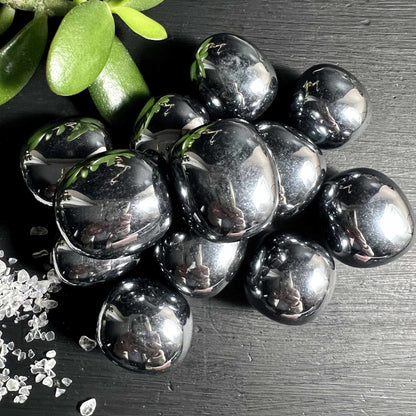  Terahertz Trommelsteine glaenzen wie fluessiges Silber auf dunklem Holz | Happy Minerals