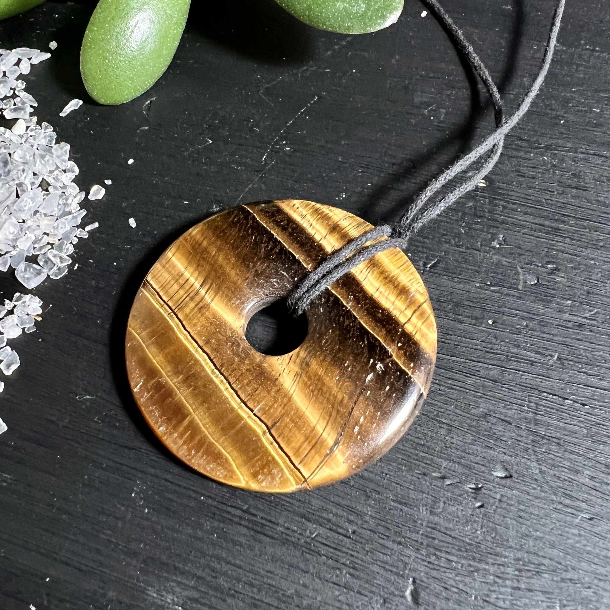 Polierter Tigerauge Donut mit Kristallen und grüner Sukkulente