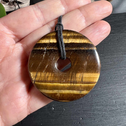 Tigerauge Donut 50mm in der Hand zeigt natürliche Streifenmaserung