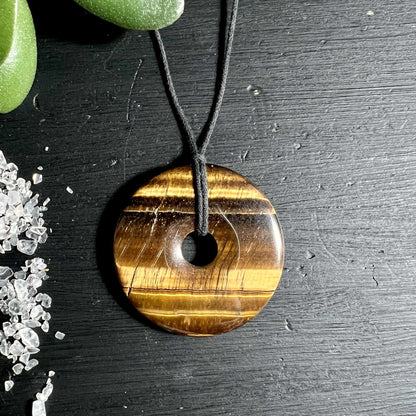 Hochglanz polierter Tigerauge Donut aus Namibia an dekorativem Treibholz