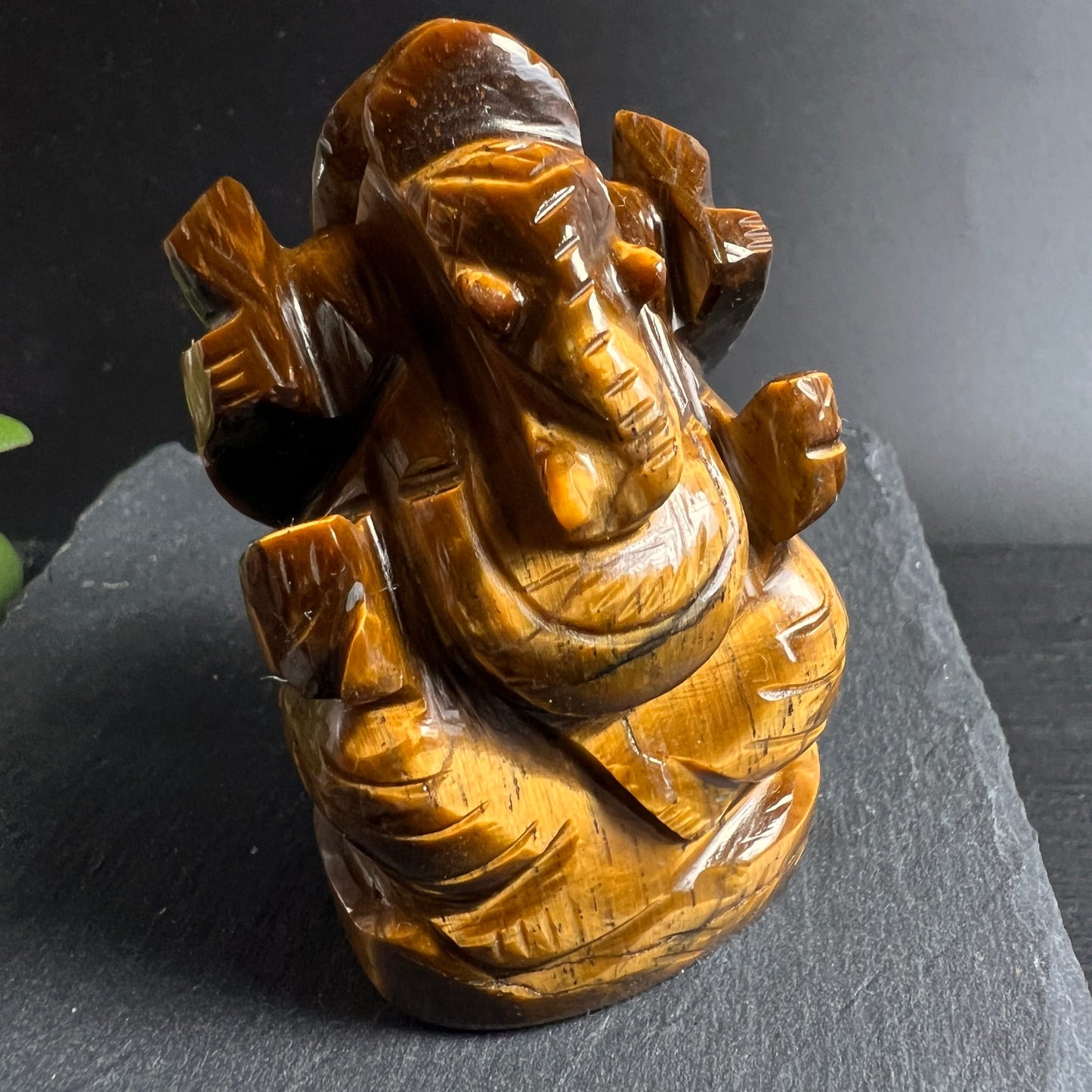 Tigerauge Ganesha | Schrägansicht rechts | honiggelbe Chatoyanz | feine Schnitzdetails | Happy Minerals