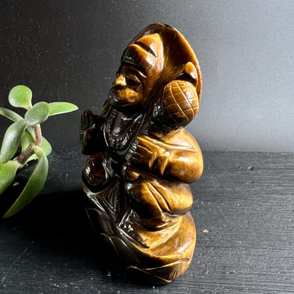 Tigerauge Hanuman | Seitenansicht rechts | detaillierte Gewandfalten | warmes Bernsteinbraun | Happy Minerals