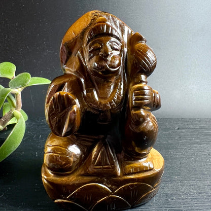 Tigerauge Hanuman Statue | Frontansicht | lachendes Gesicht | Lotussockel | Sukkulente | Happy Minerals