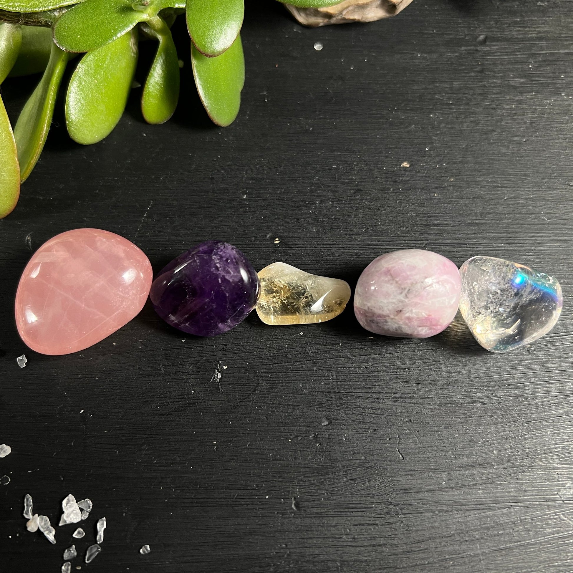 Sternrosenquarz | Amethyst | Kunzit | Citrin | Angel Aura Trommelsteine auf dunklem Holz | Happy Minerals