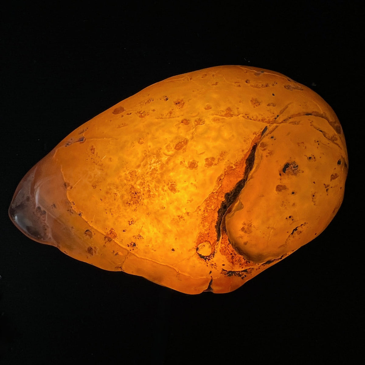 Wasserachat Handschmeichler, durchleuchtet orange-bernsteinfarben mit dunklem Riss und Wasserblase, ovale Form | Happy Minerals
