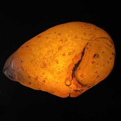 Wasserachat Handschmeichler, durchleuchtet orange-bernsteinfarben mit dunklem Riss und Wasserblase, ovale Form | Happy Minerals
